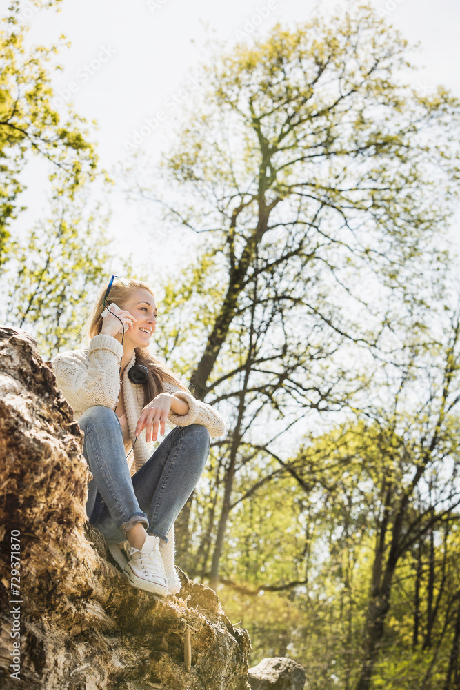 Young pretty blond girl relaxing and having fun alone in a park. Young pretty blond girl relaxing and having fun alone in a park.