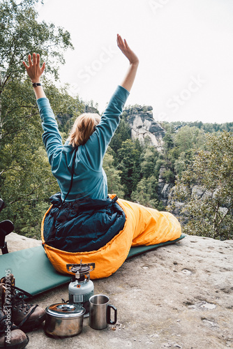 Frau streckt sich in einem Schlafsack, Camping, Trekking, Elbsandsteingebirge, Sachsen, Deutschland