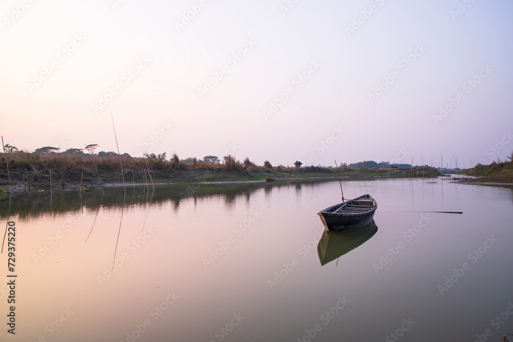 Beautiful Evening Landscape view of  Lake with a wooden boat under the blue sky
