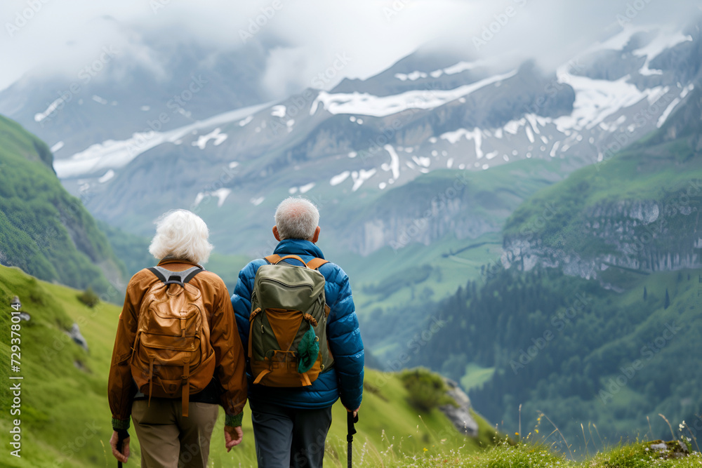 Back view of an elderly gray-haired man and an elderly woman backpacking hiking in the mountains Active healthy lifestyle seniors copy space