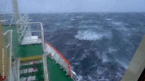Storm in ocean. Navigation bridge of the ship is covered by a wave
