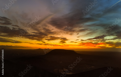 Spectacular sun set image over Volcan Calderon Hondo volcanic crater silhouetted against the setting sun and skyscape near Corralejo, Fuerteventura, Canary Islands, Spain