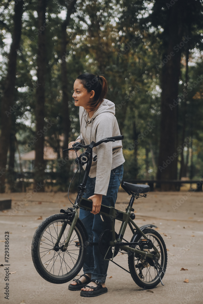 Happy Asian young woman walk and ride bicycle in park, street city her smiling using bike of transportation, ECO friendly, People lifestyle concept. Happy Asian young woman walk and ride bicycle in park, street city her smiling using bike of transportation, ECO friendly, People lifestyle concept.