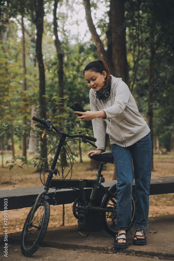 Obraz premium Happy Asian young woman walk and ride bicycle in park, street city her smiling using bike of transportation, ECO friendly, People lifestyle concept.