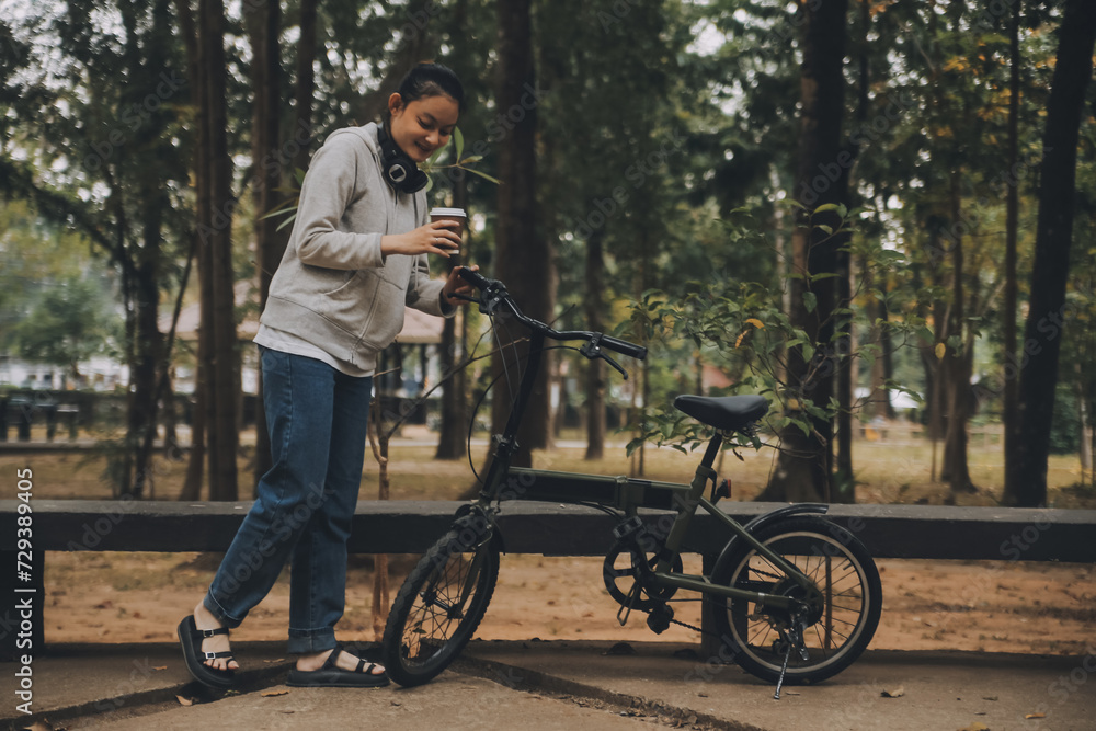 Obraz premium Happy Asian young woman walk and ride bicycle in park, street city her smiling using bike of transportation, ECO friendly, People lifestyle concept.