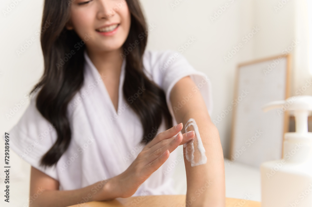 Healthy skin care, beauty asian young woman in bathrobe, towel after shower bath at home, hand in applying, putting moisturizer on her arm. Skin body cream moisturizing lotion, routine in the morning Healthy skin care, beauty asian young woman in bathrobe, towel after shower bath at home, hand in applying, putting moisturizer on her arm. Skin body cream moisturizing lotion, routine in the morning