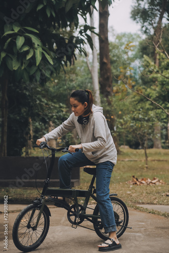 Happy Asian young woman walk and ride bicycle in park, street city her smiling using bike of transportation, ECO friendly, People lifestyle concept. © ARMMY PICCA