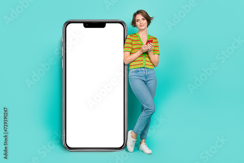 Full size portrait of pretty girl hold use smart phone big empty space banner isolated on turquoise color background
