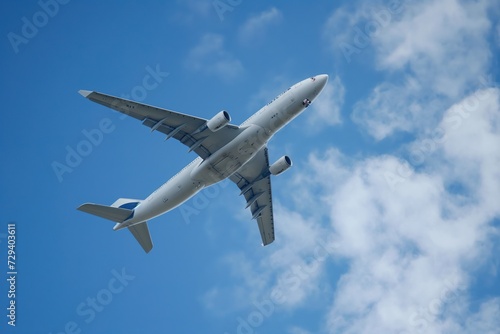 a sizeable jetliner soaring through a sky filled with billowing blue clouds.