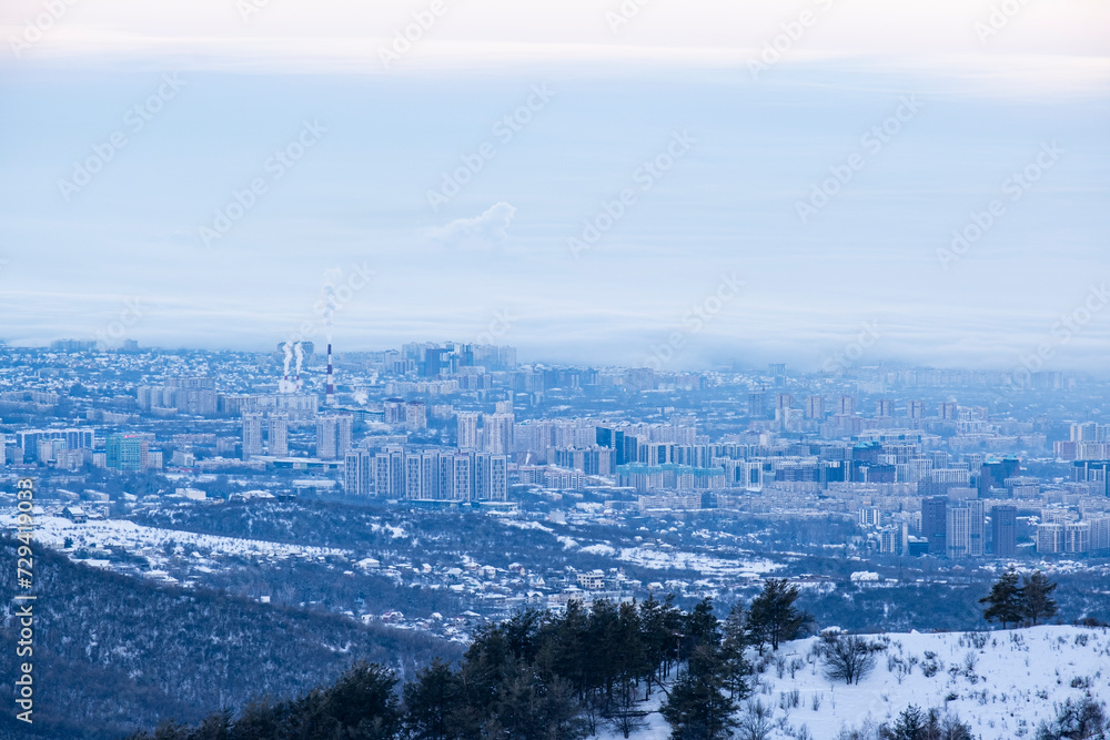 View of the city of Almaty in winter from the mountains. Almaty city before dawn.