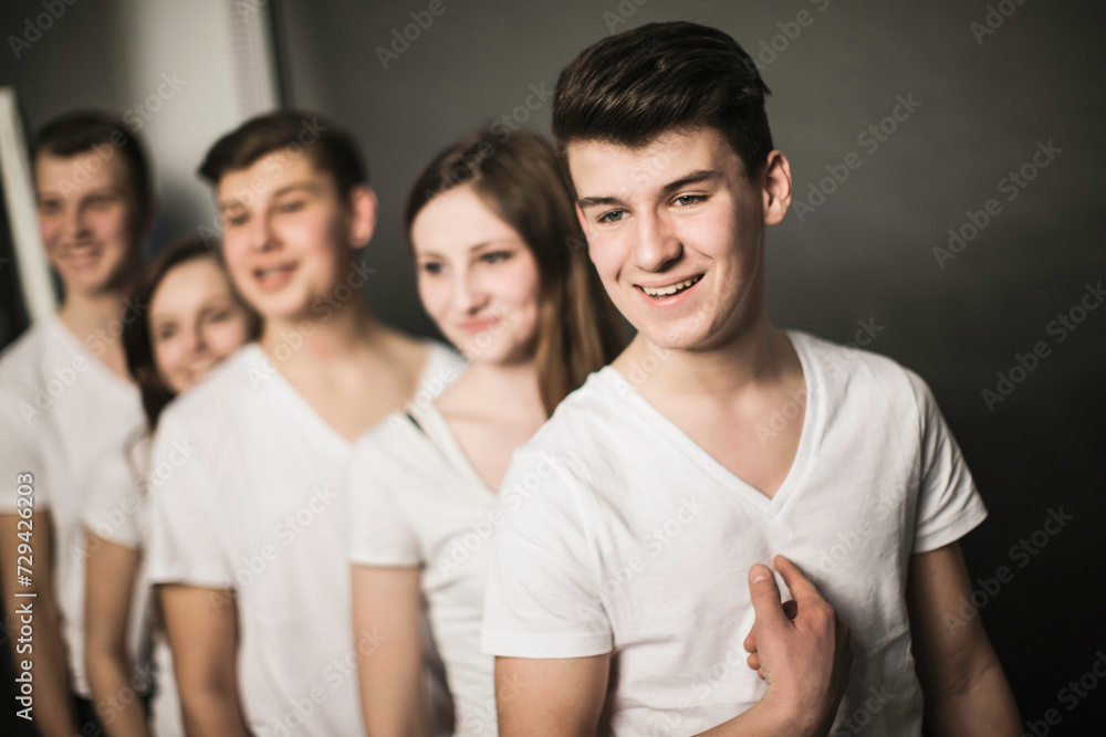Teenage kids hanging out in room, leaning on a wall and looking at tablet computers. Teenage kids hanging out in room, leaning on a wall and looking at tablet computers.