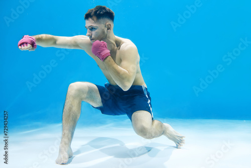 Young man boxing with clarity while in the water