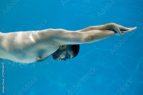 Vacation concept. Young athletic man swimming in a competition in the pool