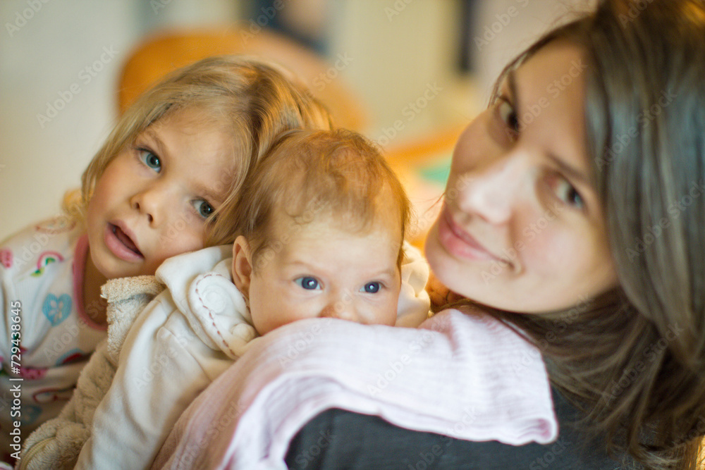 Mother with young girl and baby girl looking into camera. Munich, Germany Mother with young girl and baby girl looking into camera. Munich, Germany