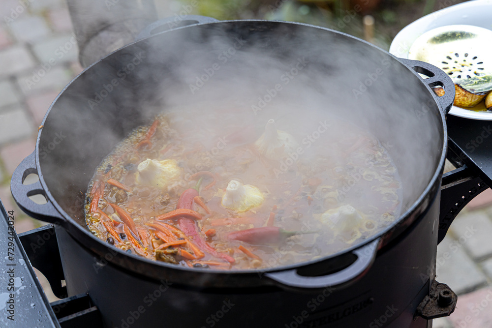 Real Uzbek pilaf in a huge cauldron. Cooking national dishes in Uzbekistan. Rice with meat in a cauldron. Traditional pilaf cooking Real Uzbek pilaf in a huge cauldron. Cooking national dishes in Uzbekistan. Rice with meat in a cauldron. Traditional pilaf cooking