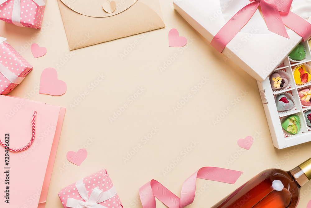 top view photo of st valentine day decor shopping, bag, wine, bottle, envelope, gift, box, candy and red heart on colored background with empty space. Frame background