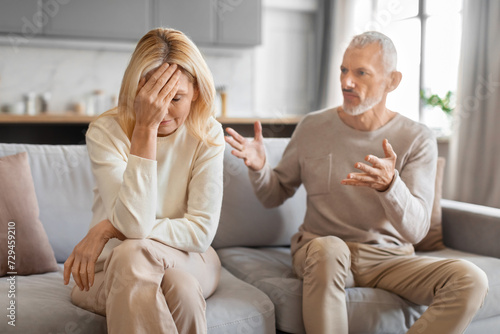 Angry elderly man yelling at his tired upset wife photo