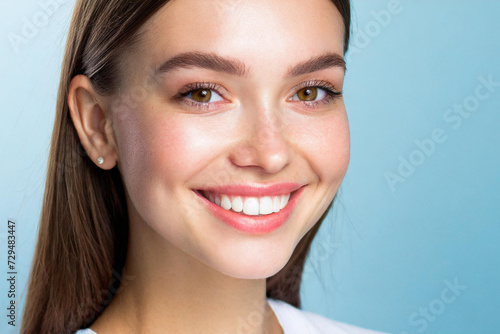 Dental care and health.Woman smile.Correct healthy care of white teeth with clean skin and make-up, beautiful female face,pure beauty,light blue background.