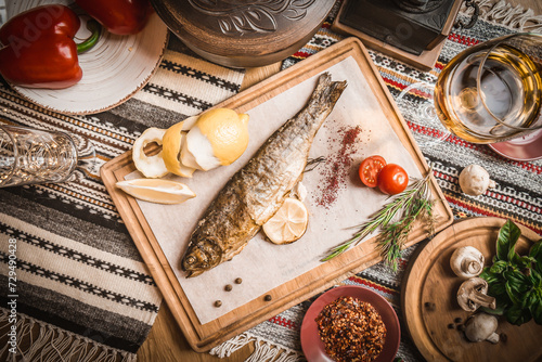 Turkish or Greek restaurant table and food dinner cuisine culture from top view. Traditional Greek ouzo or turkish raki with grilled or fried fish and appetizers on dinner table at restaurant. photo