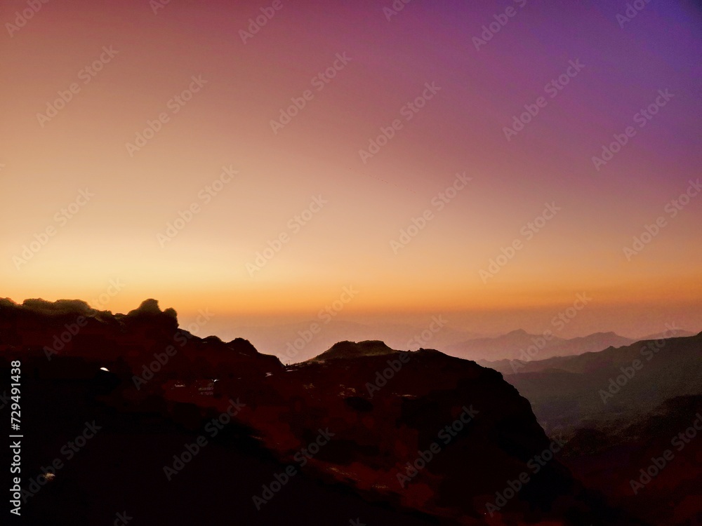 A unique view of the sunset in a colorful sky over high mountains
