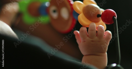 Baby hand playing with toy inside crib