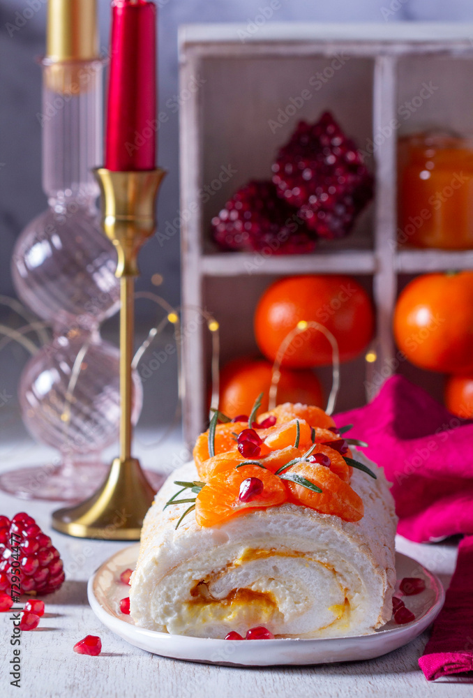 Meringue roll filled with mascarpone, cream and tangerine jam, decorated with tangerines and pomegranate seeds.