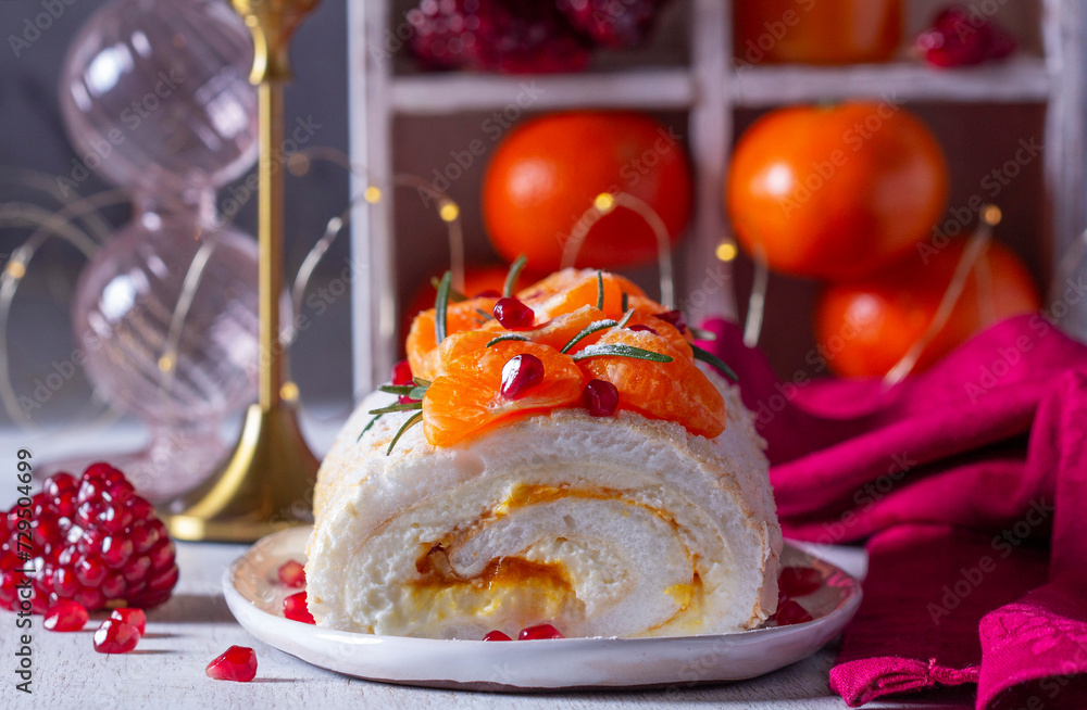 Meringue roll filled with mascarpone, cream and tangerine jam, decorated with tangerines and pomegranate seeds.