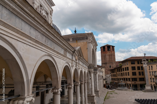 Columns under Venetian style clock tower Torre dell'Orologio on main square Piazza della Liberta in historic old town Udine, Friuli Venezia Giulia, Italy, Europe. Italian architecture with arches