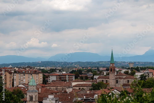 Aerial panoramic view of historic city of Udine, Friuli Venezia Giulia, Italy, Europe. Viewing platform form castle of Udine. Cloudy overcast day. Distant view of mountains of Alps, border to Austria © Chris