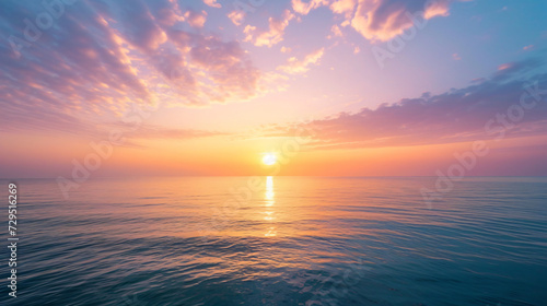 An inspiring sunrise over a calm ocean with soft hues painting the sky and reflecting on the water. photo