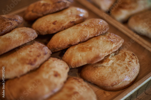 Sweetish Bakery pastry snack. Sochnik - Russian curd cake baked in the oven. Sochen sweet made from shortcrust pastry with cottage cheese filling. Fresh pastries lie in two rows on a wooden plate