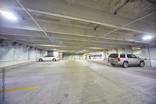 Sparse Indoor Parking Garage with Bright Lights and Two Cars © Nicholas J. Klein