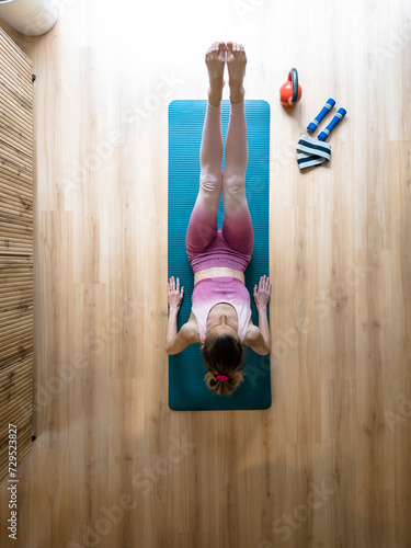 Overhead view of a fit young woman working out at home on pilates or yoga mat