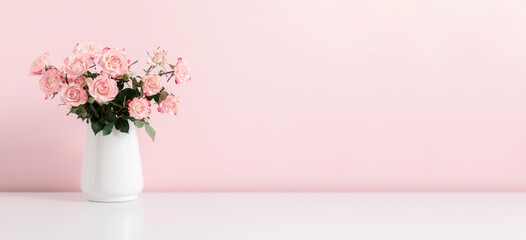 Beautiful bouquet flowers pink roses in vase on pastel pink background table. Birthday, Wedding, Mother's Day, Valentine's day, Women's Day. Front view