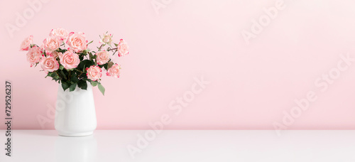 Beautiful bouquet flowers pink roses in vase on pastel pink background table. Birthday, Wedding, Mother's Day, Valentine's day, Women's Day. Front view photo