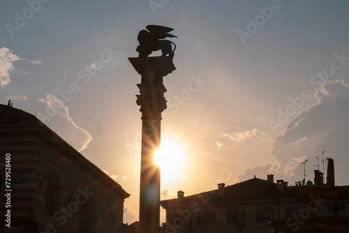 Scenic view of silhouette of statue of San Marco lion on top of column at sunrise seen from Renaissance Loggia di San Giovanni in Udine  Friuli Venezia Giulia  Italy. Landmark on Piazza della Liberta