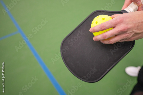hand on the pickle ball racket