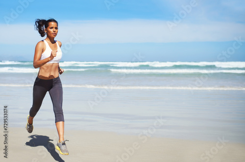 Fitness, space or Indian woman at beach running for exercise, training or outdoor workout at sea. Sports person, runner or healthy female athlete on sand for cardio endurance, wellness or mockup