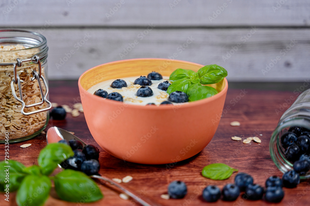 Breakfast table with a bowl of yogurt complemented with blueberries and oatmeal. Breakfast table with a bowl of yogurt complemented with blueberries and oatmeal.