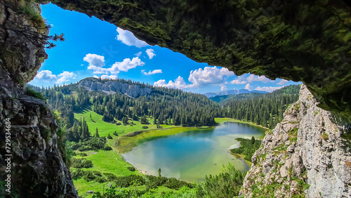 Idyllic cave Drachenhoehle with panoramic view of alpine lake Sackwiesensee in Hochschwab mountains, Styria, Austria. Wanderlust in wilderness of Austrian Alps, Europe. Natural arch rock formation photo