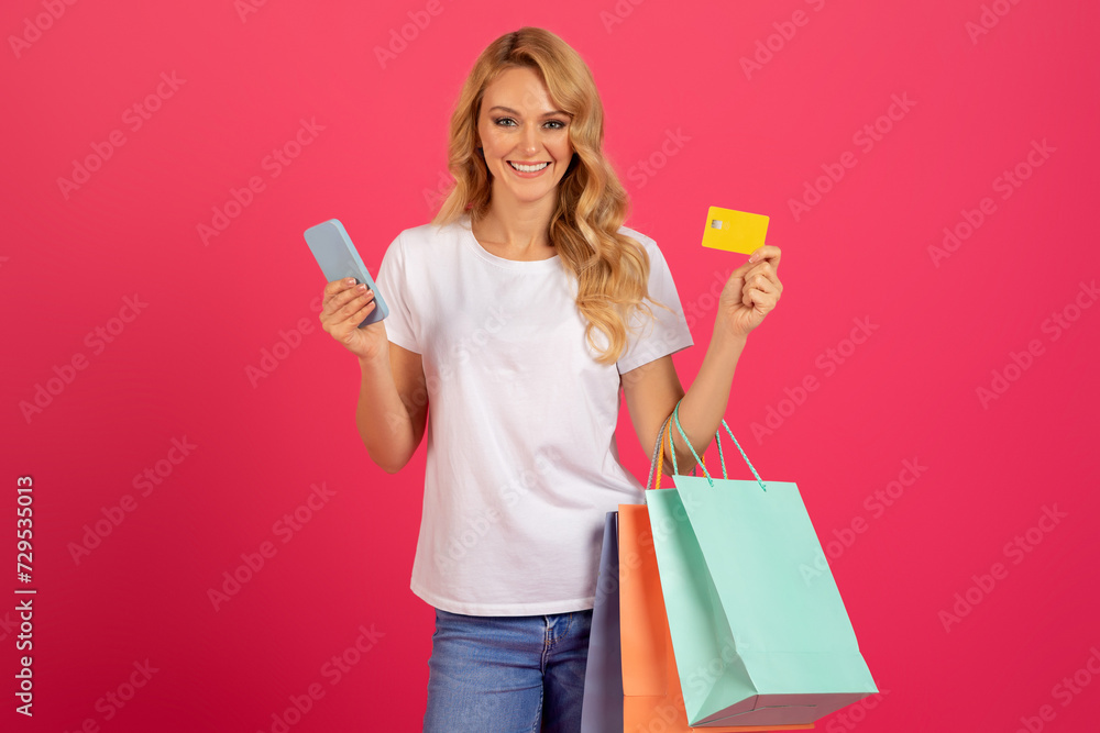 blonde lady shopping holding credit card and mobile phone, studio blonde lady shopping holding credit card and mobile phone, studio