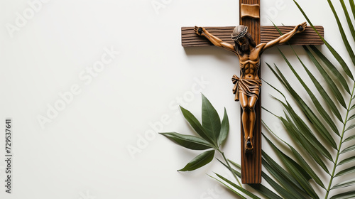 Crucifix with figure of Jesus, red candle and palm leaves on white background photo