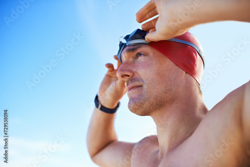 Beach, goggles and man with holiday, cap and swimmer with adventure and summer break with getaway trip. Person, athlete and player with protection and seaside with sunshine and fitness with wellness