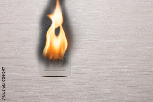 An electrical outlet on the inner wall of a residential building burns and smokes. Electrical short circuit. copy space. photo