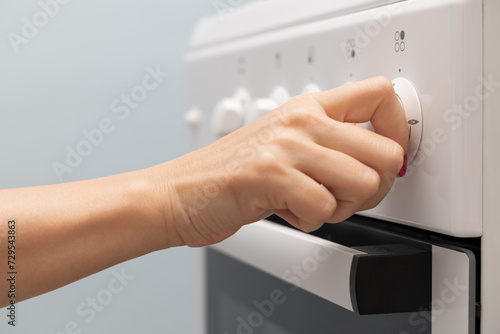 Canvas-taulu a woman's hand rotates the selector on a gas stove.