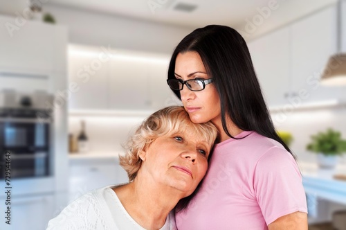 Old mom and young teen daughter at home.