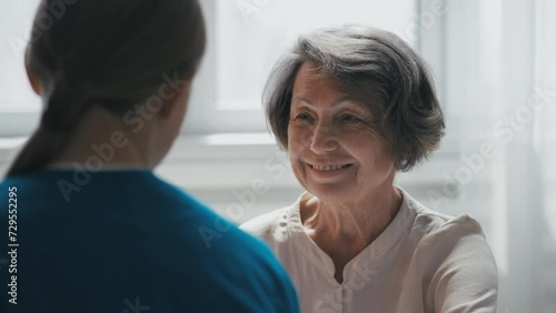 Warm conversation between hospital staff and elderly patient, home care services photo