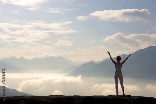 Woman in yoga pose standing on a mountain peak, copy space background wallpaper © Radmila Merkulova