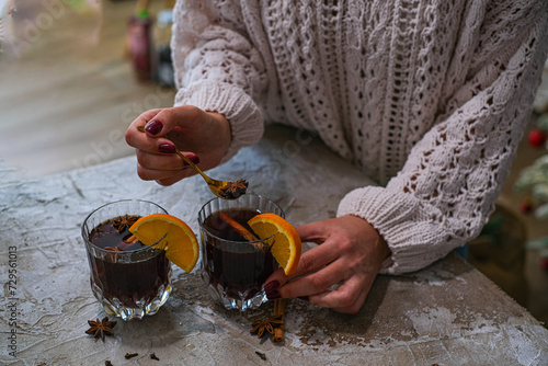 Young Woman holding glass of hot mulled wine. Homemade hot spicy wine. High quality photo photo