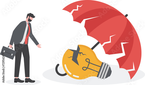 Business crisis and default concept. sad frustrated businessman standing looking at broken light bulb under a broken umbrella.


